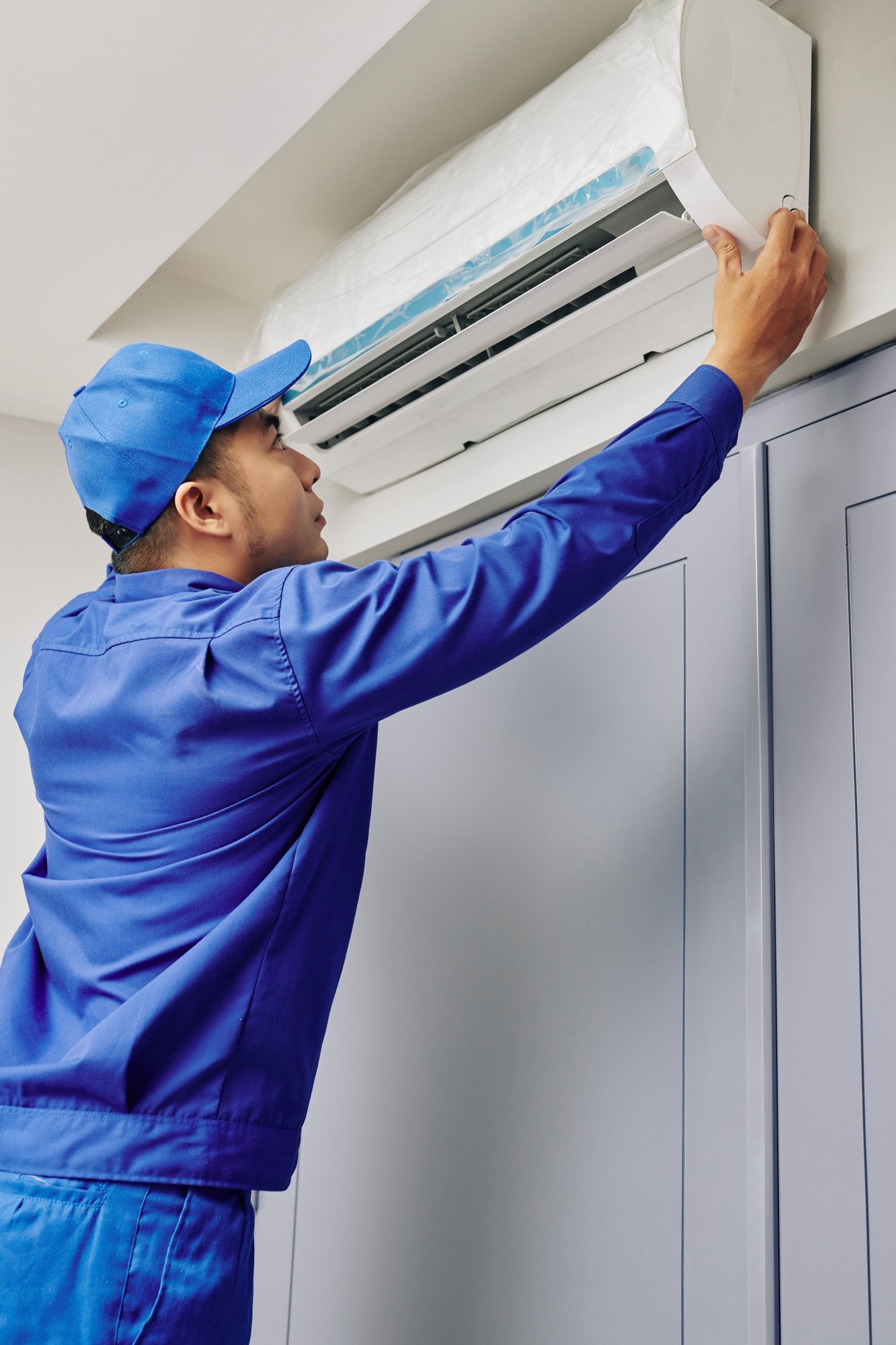 Repairman checking broken air conditioner